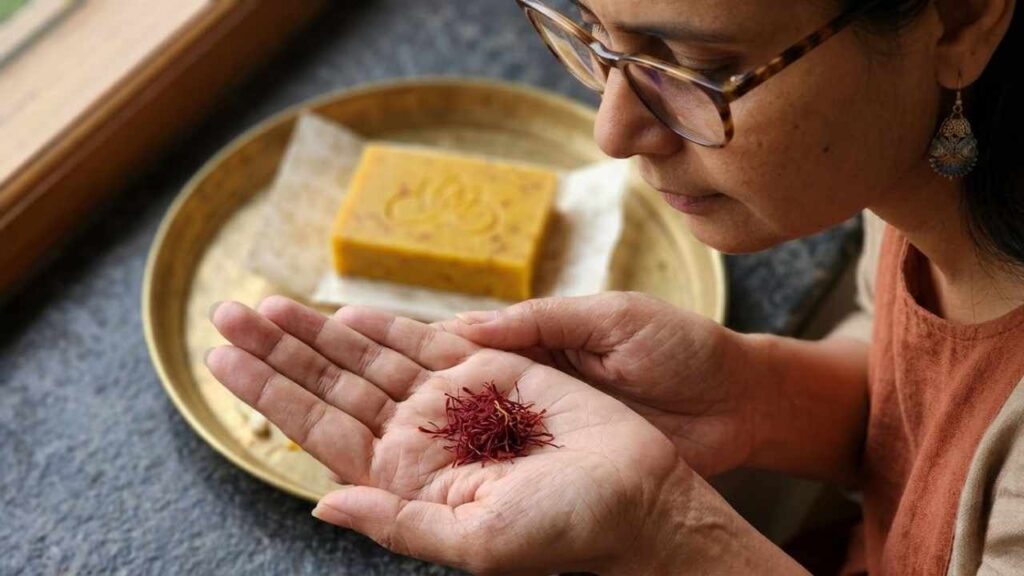 Grade A Kashmiri Kesar saffron threads held in hands — Avyaya Rituals sacred morning ritual ingredient